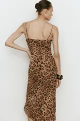 Vestido midi cortado al bies con ajuste entallado y caída suave, con estampado de leopardo, breteles finos ajustables, escote corazón con cordón y copas fruncidas.