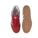 Championes Adidas modelo Gazelle Indoor, color rojo con las icónicas tres rayas laterales en blanco. Presentan una parte superior de gamuza, lengüeta texturizada y suela de goma color caramelo con el logo de Adidas grabado.