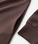 Buzo de pijama con capucha ajustable y cordones, confeccionado en tejido de modal con acabado suave. Presenta mangas largas, puños y ruedo acanalados, ofreciendo un calce holgado y confortable.