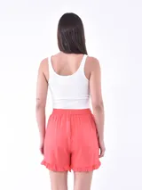 Short de tela fluida color coral, con cintura elástica, cordón de ajuste y detalle de volados en el ruedo.