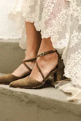 Zapato de tacón bajo color negro, con punta en V, tiras cruzadas en el empeine y cierre de hebilla en el tobillo. El tacón es ancho y mide 5 cm.