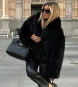 Chaqueta de piel sintética color negro, con cuello solapa amplio y diseño de pelo largo.