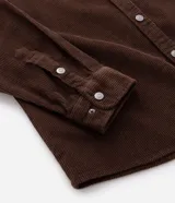 Camisa de terciopelo cotelé color negro, de corte clásico con cuello solapa, manga larga, cierre frontal de botones y un bolsillo aplicado en el pecho.