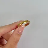 Anillo dorado fino de acero con forma irregular.