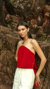 Top rojo de cuero pecarí con aplique de bronce en el cuello y espalda ajustable.