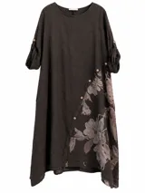 Vestido midi color marrón chocolate con diseño asimétrico abotonado en diagonal, detalle de estampado floral en el lateral y mangas largas con presillas y botones para sujetar arremangadas.