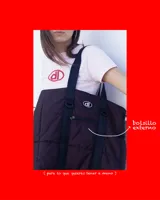 Bolso tipo tote de diseño urbano, confeccionado en material impermeable acolchado de color negro. Cuenta con doble asa de hombro, compartimento principal con cierre, bolsillo frontal con cierre y detalle de logo circular en la parte superior.