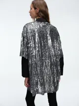 Vestido corto de corte recto y holgado, confeccionado en tejido cubierto de lentejuelas doradas. Presenta cuello redondo, mangas cortas amplias y una caída fluida.