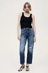 Jean tobillero de cinco bolsillos en denim de algodón, de tiro alto con piernas rectas y detalles de roturas sutiles.