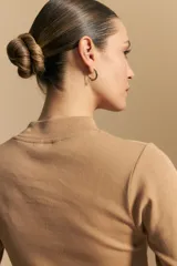 Polera de manga larga color marrón claro, con cuello alto y costura vertical decorativa en el frente.