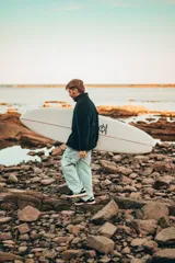 Buzo negro de polar con cierre parcial y logo de la marca bordado en el pecho.