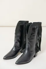 Bota de caña media estilo western, color negro, confeccionada en cuero vacuno. Presenta puntera afilada, taco medio y detalles de gamuza en el cuello, con flecos colgantes en la parte trasera. Posee cierre en el costado interno para facilitar el calce.