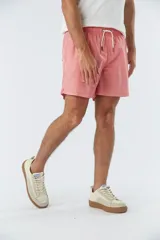 Short de baño liso color salmón, con cintura elástica ajustable mediante cordón, dos bolsillos laterales y un bolsillo posterior.