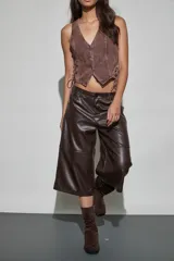 Bermuda de cuerina color marrón oscuro, de corte ancho y largo por debajo de las rodillas, con diseño de tiro medio y costuras horizontales en las piernas.