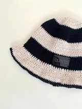 Gorro tipo bucket tejido a crochet a mano, con hilo 100% algodón, con diseño a rayas horizontales en color marrón y beige.