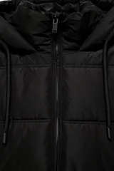 Anorak acolchado de corte corto en color negro, con capucha ajustable, cierre frontal de cremallera y bolsillos laterales. Cuenta con puños interiores y bajo ajustable con cordones elásticos.