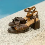 Sandalias de cuero color dorado, con plataforma y taco cuadrado. Presentan tiras cruzadas en el empeine y pulsera al tobillo con hebilla.