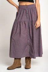 Falda midi de algodón con estampado de cuadros gingham en tonos rosa y azul marino. Tiene corte acampanado, cintura alta y botonadura frontal.