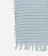 Pañuelo de textura maquinetada en color celeste, con bordes desflecados.