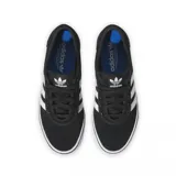 Championes adidas Adiease de estilo urbano, confeccionados en gamuza negra con las icónicas tres tiras laterales en blanco. Presentan una suela de goma vulcanizada blanca con detalle de línea negra y puntera reforzada.