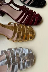 Sandalias de cuero acharolado color borgoña con puntera calada, pulsera ajustable y taco cuadrado de 5cm.