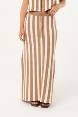 Falda larga tejida a rayas verticales color beige y blanco, con pretina elástica y tajos laterales.