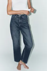 Jeans de tiro alto con corte mom fit, cinco bolsillos y cierre frontal con cremallera y botón metálico.
