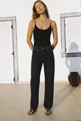 Jeans de tiro alto y corte recto de pernera larga, con diseño clásico de cinco bolsillos y costuras en contraste. Cierre frontal con cremallera y botón metálico.
