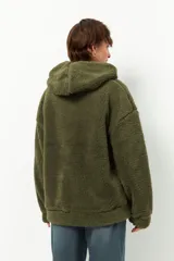 Campera tipo canguro teddy negra con capucha y cierre. El forro es de felpa color verde militar.