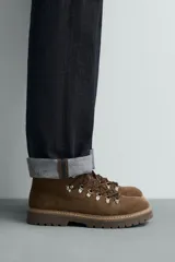 Bota de caña baja con acabado en serraje, horma redonda y suela track con volumen.