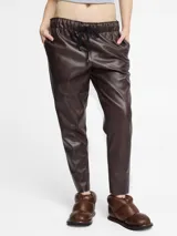 Pantalón de corte slim fit con acabado de efecto cuero vintage, color marrón oscuro. Presenta cintura elástica con cordón de ajuste y bolsillos laterales.
