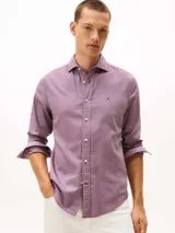 Camisa de manga larga Tommy Hilfiger con corte regular, confeccionada en algodón con tejido dobby texturizado. Presenta un micro estampado de puntos en tono rojizo, cuello clásico con botones y logo de la marca bordado en el pecho.