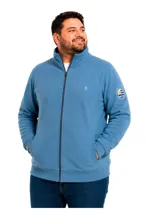 Campera de micropolar color azul, con cierre frontal completo, cuello alto y bolsillos laterales. Presenta un pequeño logo bordado en el pecho y un parche circular con la bandera de Uruguay en la manga izquierda.
