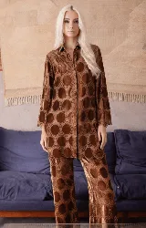 Camisa de corte oversize y manga larga, confeccionada en una combinación de encaje y círculos de terciopelo color marrón. Presenta cierre frontal con botones transparentes y un diseño holgado.