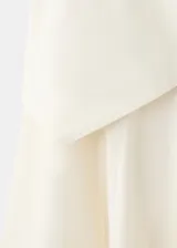 Falda larga color beige de algodón, con diseño evasé, tiro medio, forro interior y detalle cruzado tipo pañuelo con cierre de nudo en la cintura.
