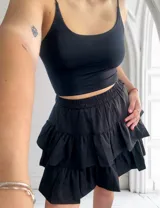 Minifalda negra con cintura elastizada y volados en capas.