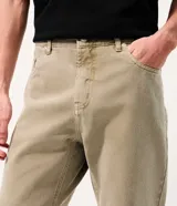 Pantalón recto de sarga color beige, con cierre frontal de botón y cremallera, y bolsillos funcionales.