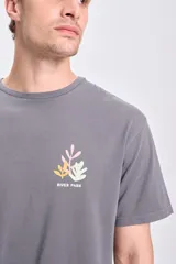 Remera gris oscuro de manga corta, corte oversize y estampa en la espalda con texto y diseño de hojas.