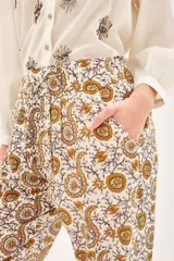 Babucha de voile de algodón con estampado tipo paisley en tonos tierra. Presenta un diseño holgado con lazos internos en el ruedo y botones para ajustar el largo.