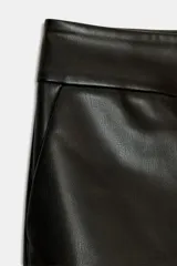 Shorts de tiro bajo confeccionados en material con efecto piel. Presentan bolsillos laterales, falsos bolsillos traseros con solapa y cierre frontal con cremallera, botón interior y gancho metálico.