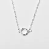 Colgante plateado con cadena de eslabones y dije circular con borde de pequeñas esferas.