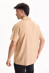 Camisa de manga corta negra, de corte clásico y cuello camisero.
