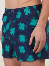 Bóxer de algodón blanco con estampado de flores pequeñas color celeste, con cintura elástica y logo de la marca en el centro.