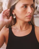 Gargantilla rígida de diseño minimalista, elaborada en metal dorado con acabado pulido, que se ajusta suavemente al cuello.