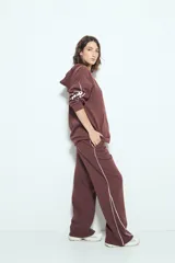 Pantalón babucha negro de silueta amplia y caída relajada, con detalle de líneas blancas laterales y cintura elastizada.