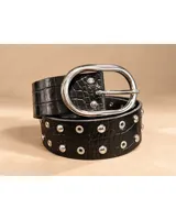 Cinto de cuero negro con textura de serpiente, hebilla ovalada plateada y detalles de tachas y ojalillos metálicos.