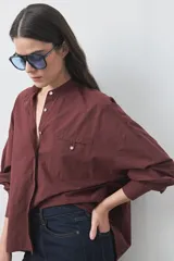 Camisa de manga larga en color celeste, con cuello mao y cierre frontal oculto. Presenta un diseño de silueta relajada con sisa caída y un bolsillo aplicado en el pecho.