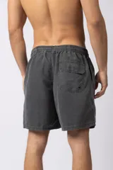 Short de baño de corte relajado en color gris azulado con efecto lavado. Cuenta con cintura elastizada con cordón ajustable, bolsillos laterales y una pequeña etiqueta decorativa en el ruedo.