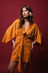 Vestido corto tipo kimono color naranja, de lino con microbrillo, con mangas amplias y tiras ajustables en la cintura.
