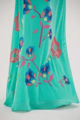 Vestido largo color verde agua con estampado de flores azules y rojas.